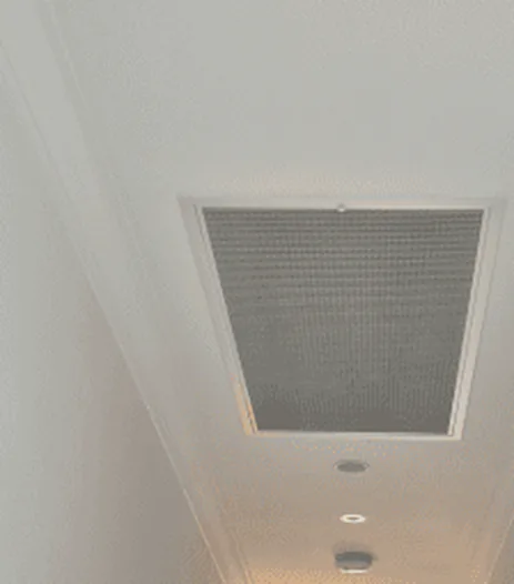 Ducted air conditioning return grille in a hallway ceiling