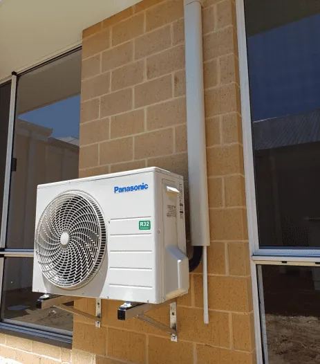 Panasonic split system outdoor unit mounted on a brick wall