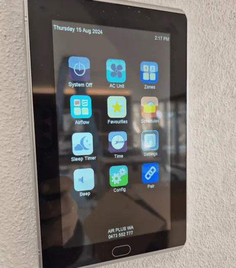 Wall mounted touchscreen air conditioning controller showing zone controls